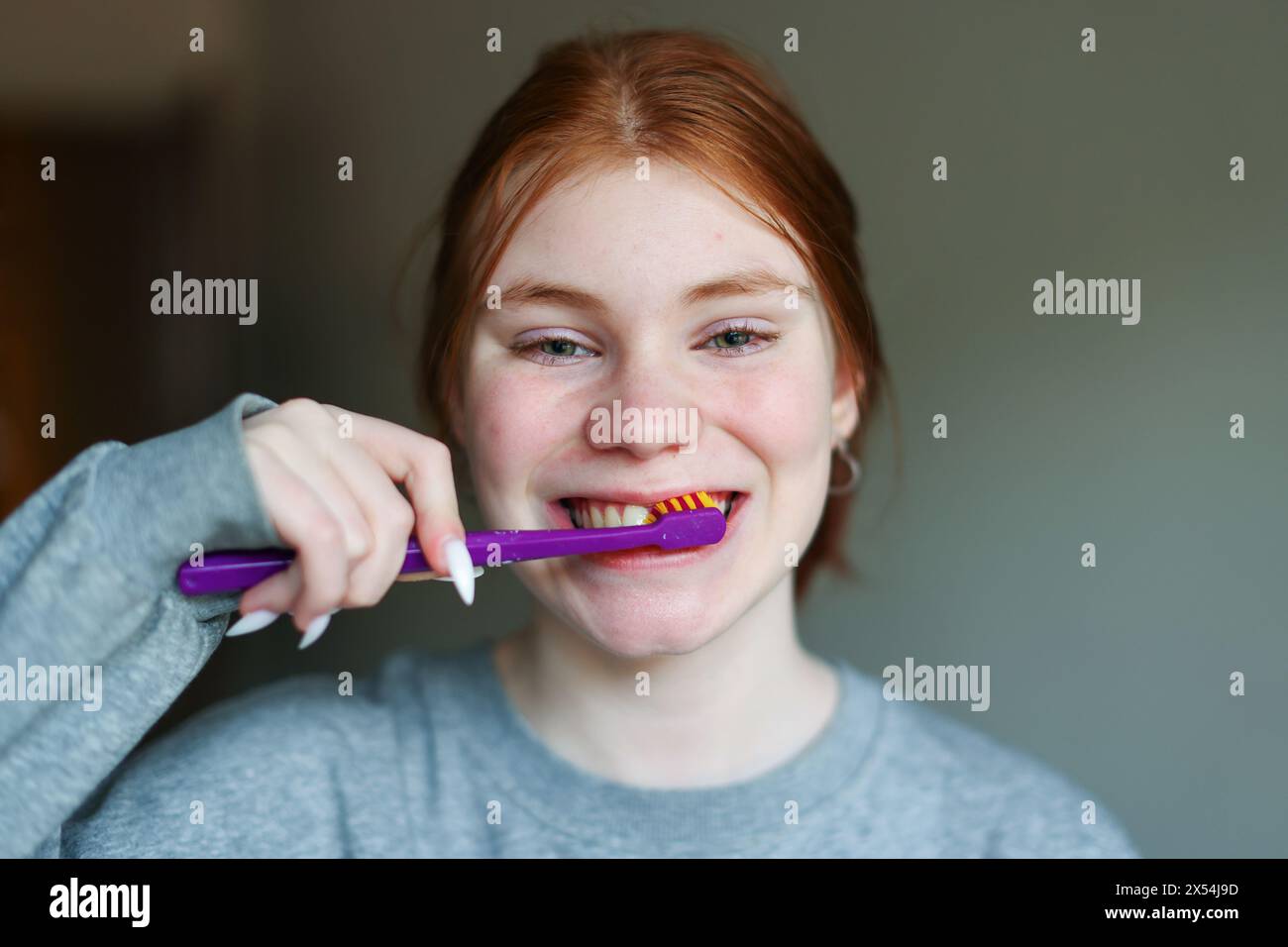 Young woman brushing teeth with charcoal toothpaste Stock Photo Alamy