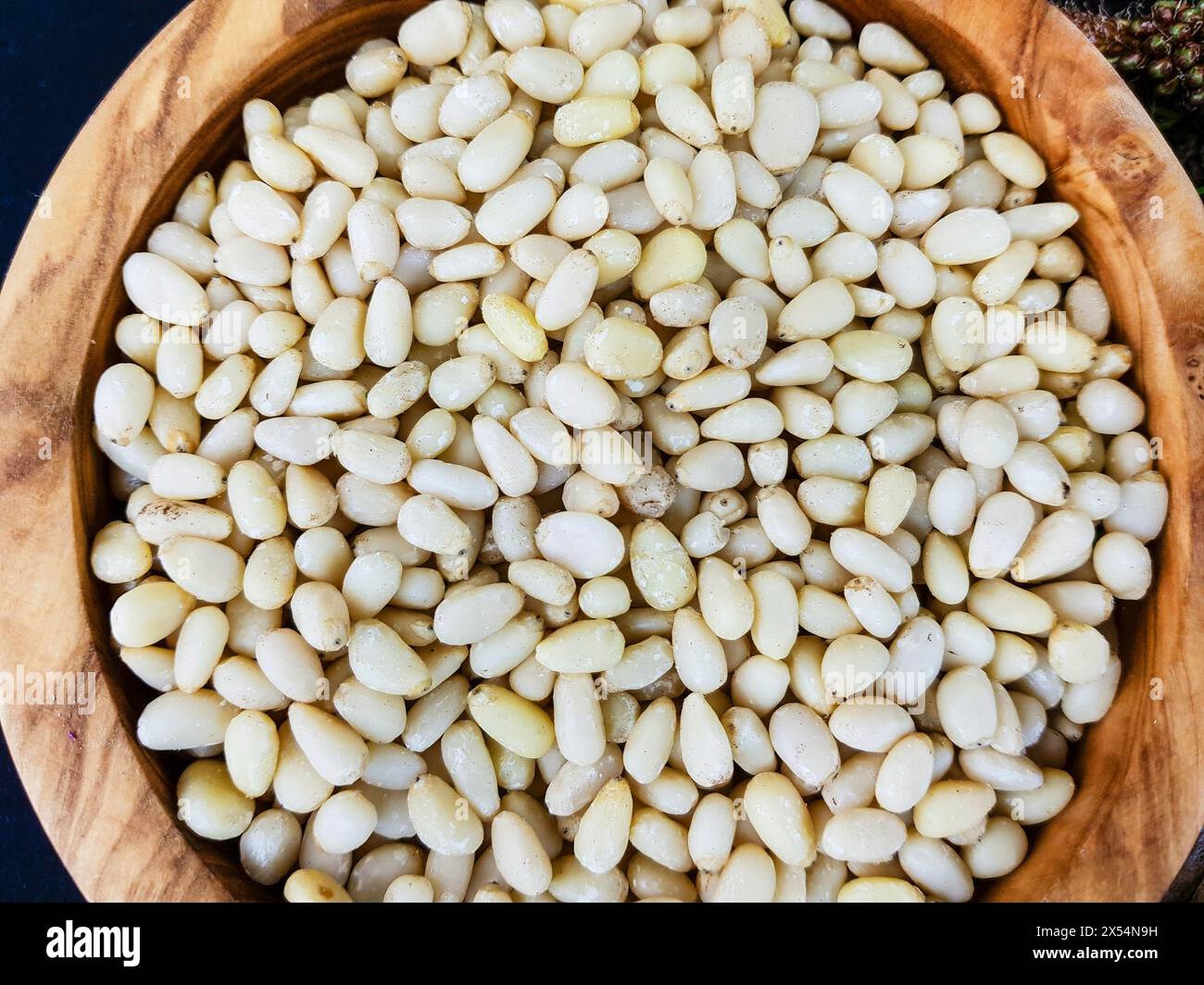 Stone pine, Italian Stone pine, Umbrella Pine (Pinus pinea), Pine nuts in a wooden bowl Stock Photo