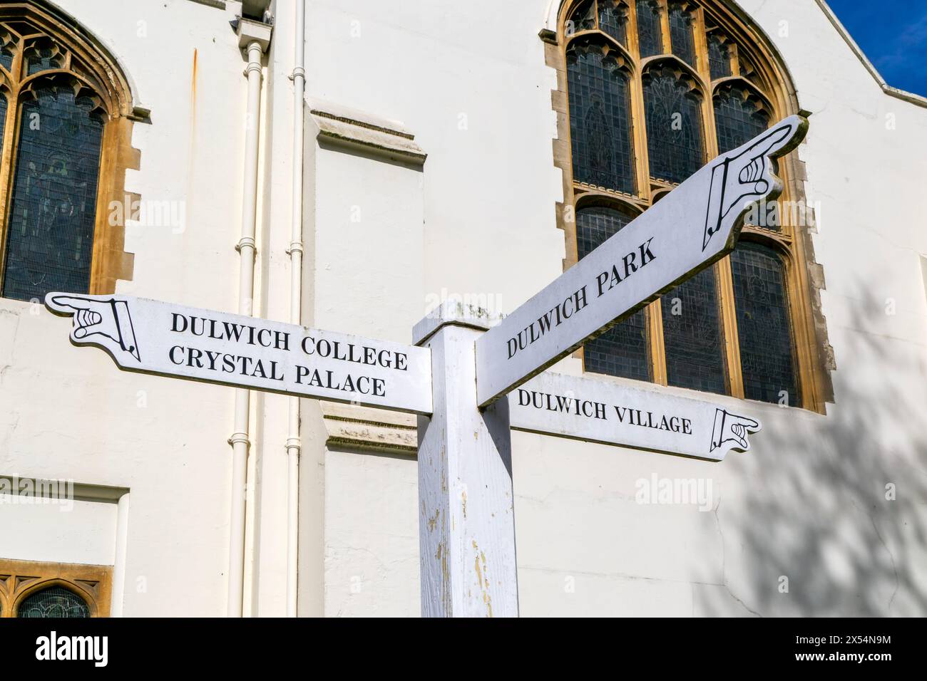 Direction pointing signpost outside Dulwich College chapel, Dulwich, London, England, UK Stock Photo