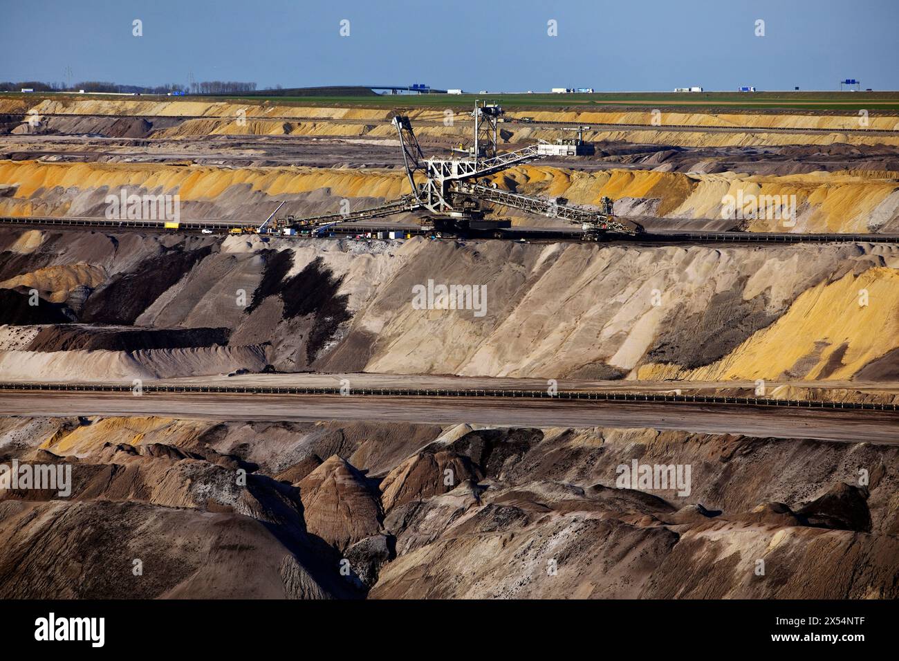 Stacker in the Garzweiler opencast lignite mine, motorway in the background, Germany, North Rhine-Westphalia, Rhineland, Juechen Stock Photo