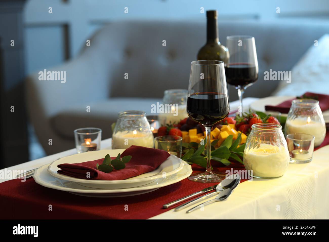 Stylish table setting with burning candles and wine indoors. Romantic ...