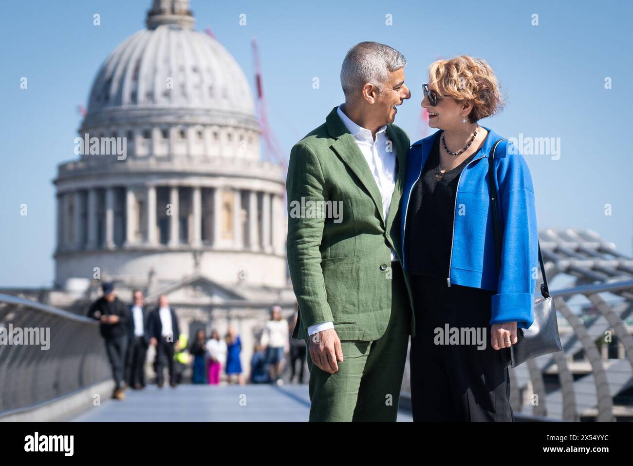 Sadiq Khan and his wife Saadiya walk across the Millennium Bridge toward the Tate Modern in London, where he signed the Declaration of Acceptance of Office to begin his third term as the Mayor of London. Picture date: Tuesday May 7, 2024. Stock Photo