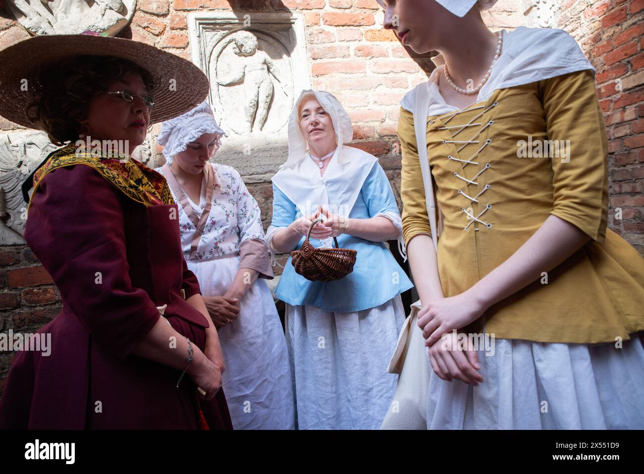 Women dressed in historic bourgeois outfits wait for the start of the changing of the guard during the 3rd May Constitution Day celebration in Gdansk. On 3 May 2024, the historic changing of the guard took place at the Prison Tower in Gda?sk. Then the re-enactors in period costume walked down D?uga Street towards Artus Court, where they took the oath based on the original text, the tradition of which dates back to the second half of the 17th century. The changing of the guard of the Gdansk garrison under the prison tower in Gdansk is linked to the adoption of the Constitution of the Polish-Li Stock Photo