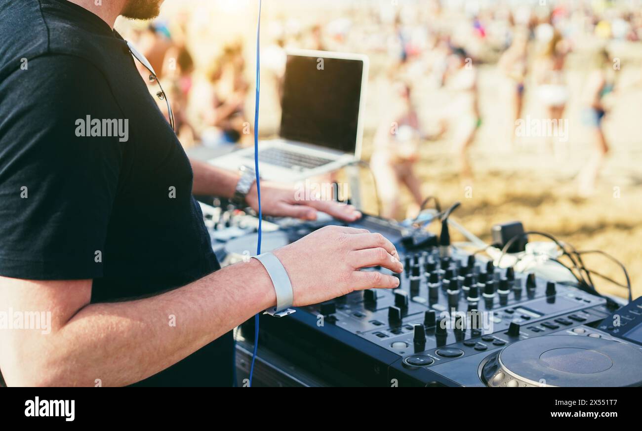 Dj mixing music at beach party during summer event - Entertainment and holidays concept -  Focus on right hand Stock Photo