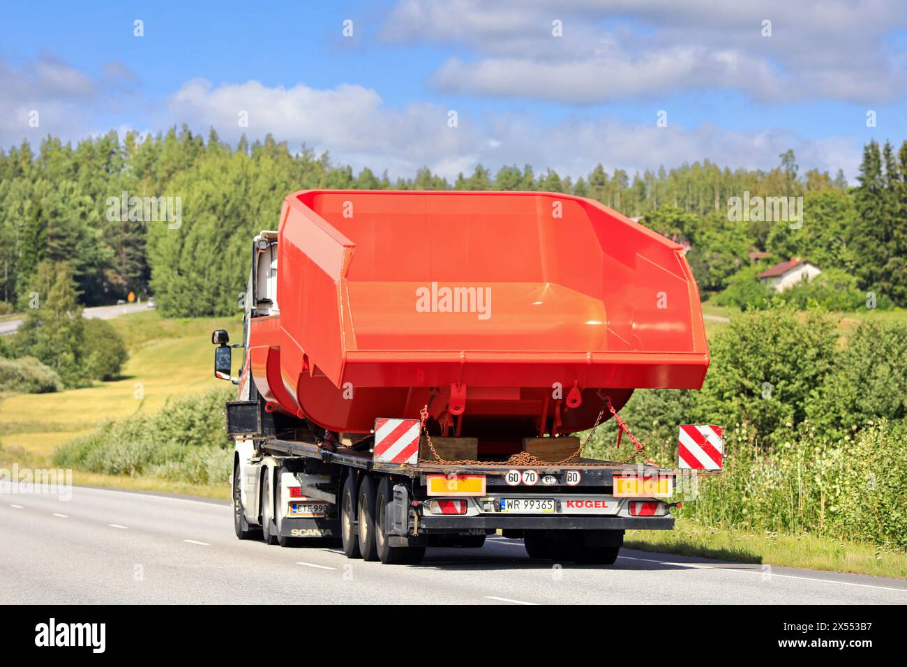 Scania R580 truck transports mining truck dump bodies on Koegel flatbed trailer as exceptional load, rear view. Salo, Finland. August 9, 2023. Stock Photo
