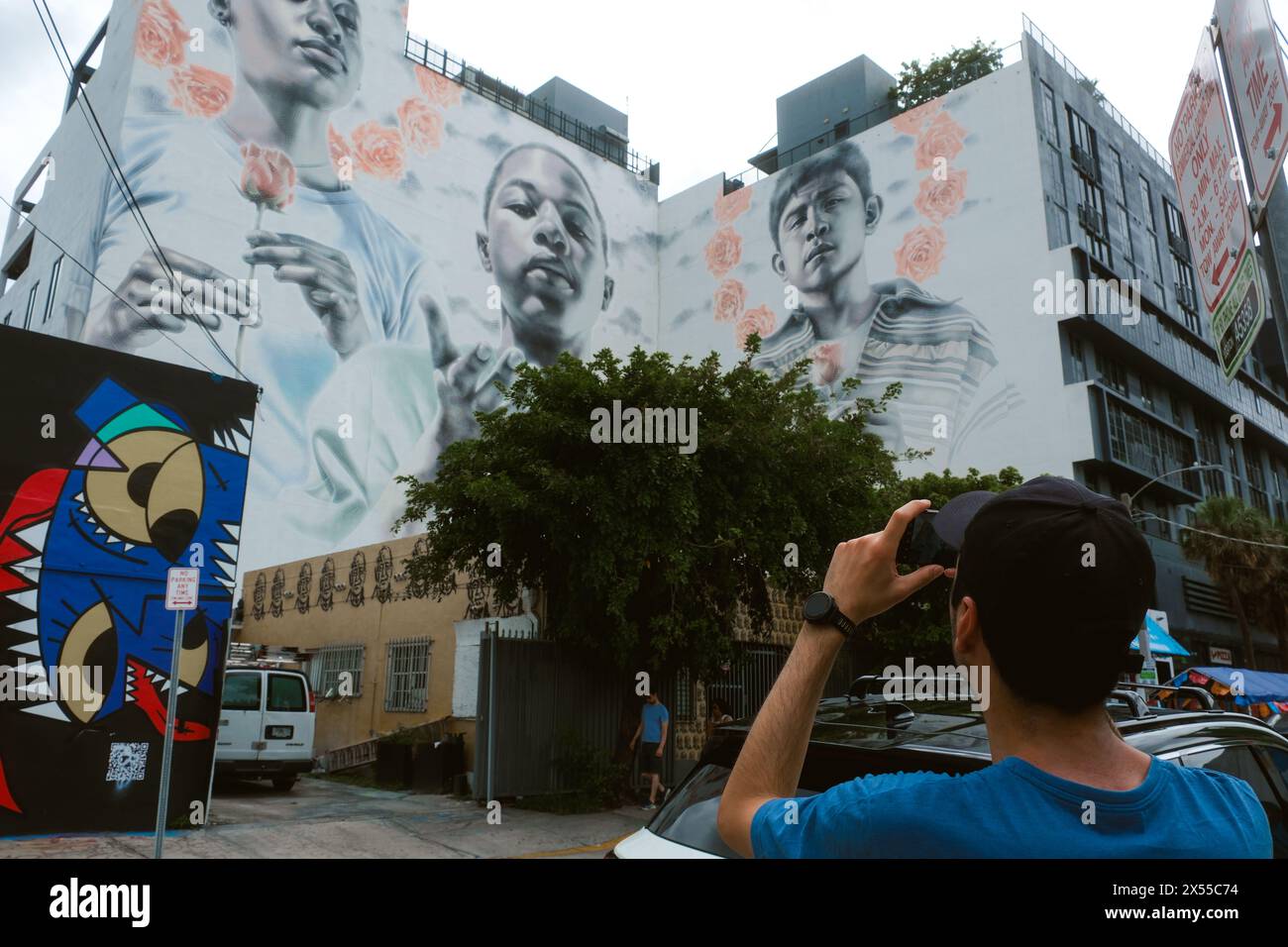 Tourist Taking A Photo Of A Famous Mural In The Wynwood Neighborhood. Miami Neighborhood With Colorful Painted Walls, Murals And Graffiti Stock Photo