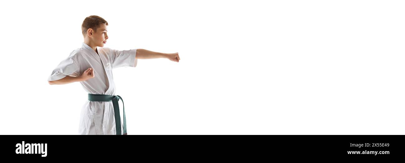 Focused martial arts student in white kimono and green belt training