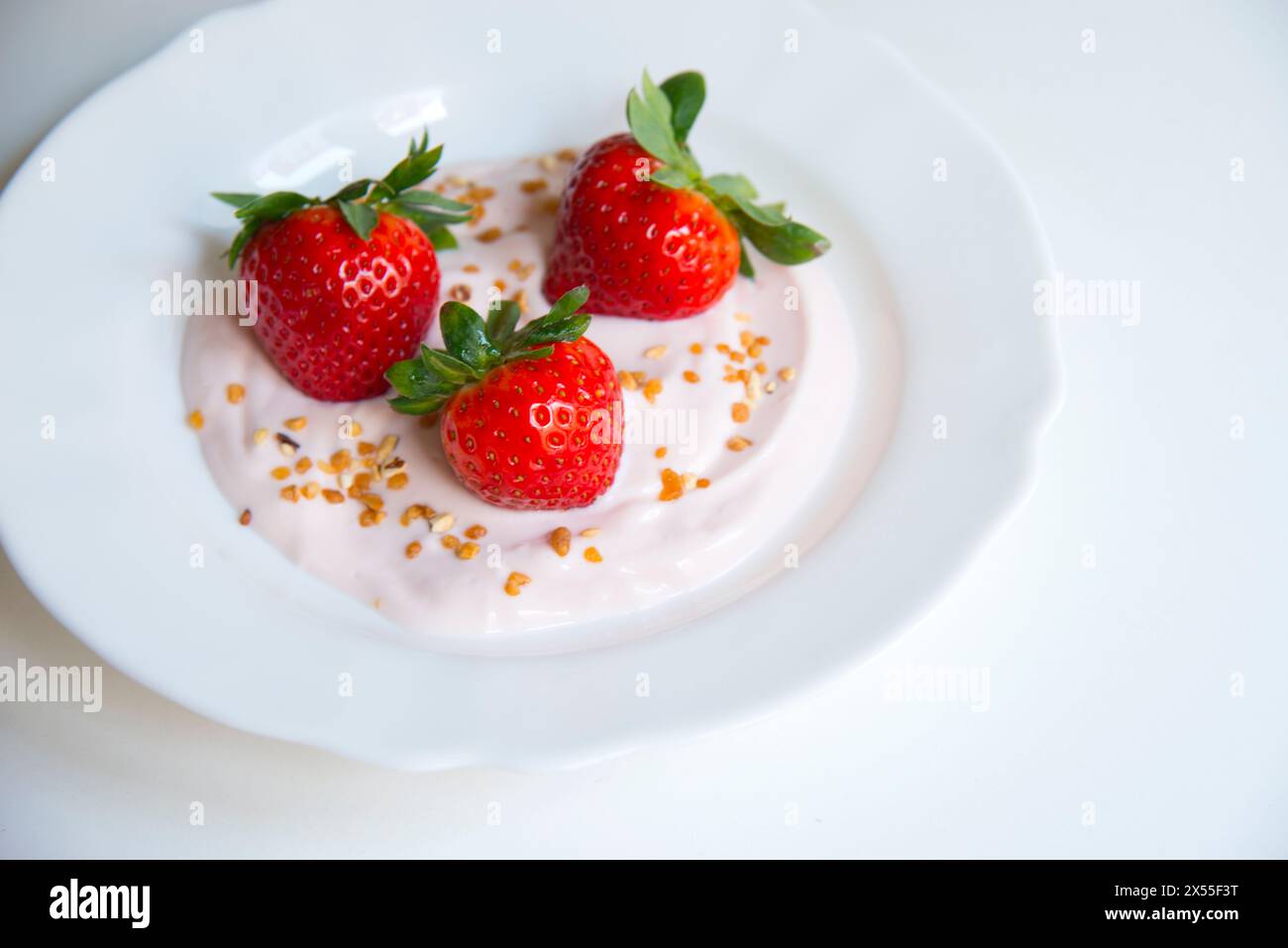 Three strawberries in strawberry cream. Stock Photo