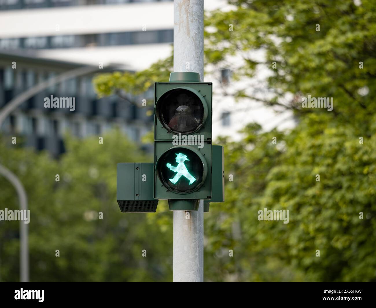 Pedestrian traffic light in Germany. Green light icon at an intersection. Crossing the road is allowed during the walking man symbol. Stock Photo