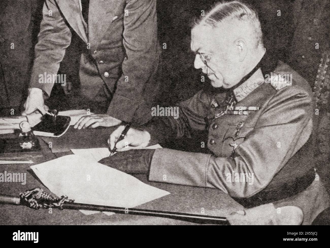 Field-Marshal Wilhelm Keitel signs the ratified terms of unconditional surrender in Berlin, 8 May 1945.  Wilhelm Bodewin Johann Gustav Keitel, 1882 – 1946. German field marshal who held office as chief of the Oberkommando der Wehrmacht (OKW), the high command of Nazi Germany's armed forces, during World War II.  From The War in Pictures, Sixth Year. Stock Photo