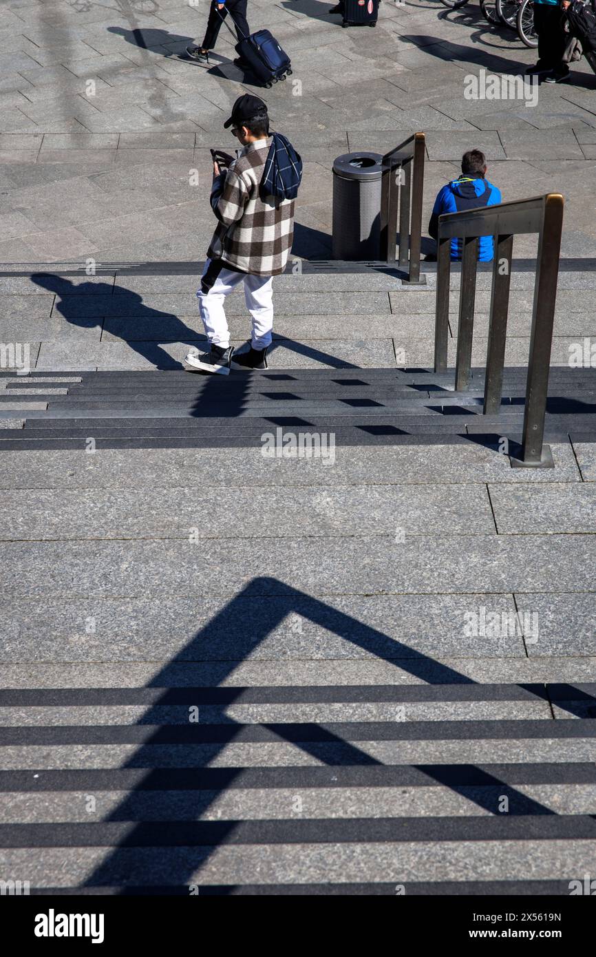 man with plaid jacket standing at the stairs from the station forecourt to the cathedral, Cologne, Germany. Mann mit karrierter Jacke steht an der Tre Stock Photo