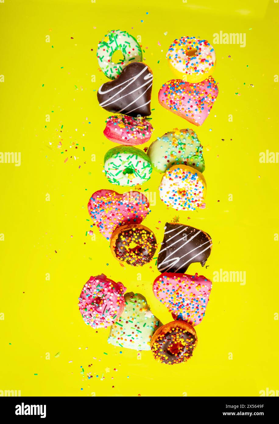 Multicolored donuts isolated on yellow background. Top view Stock Photo