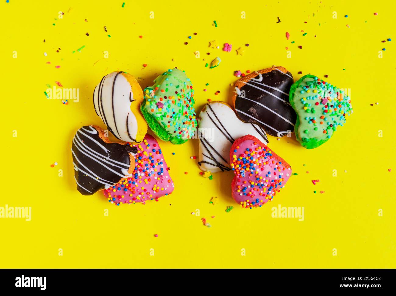 Multicolored donuts isolated on yellow background. Top view Stock Photo