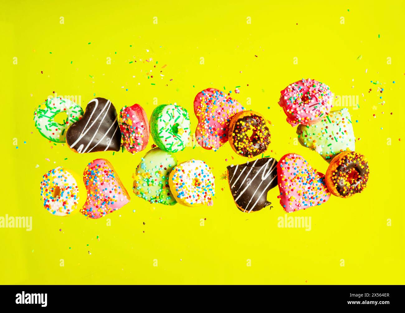 Multicolored donuts isolated on yellow background. Top view Stock Photo