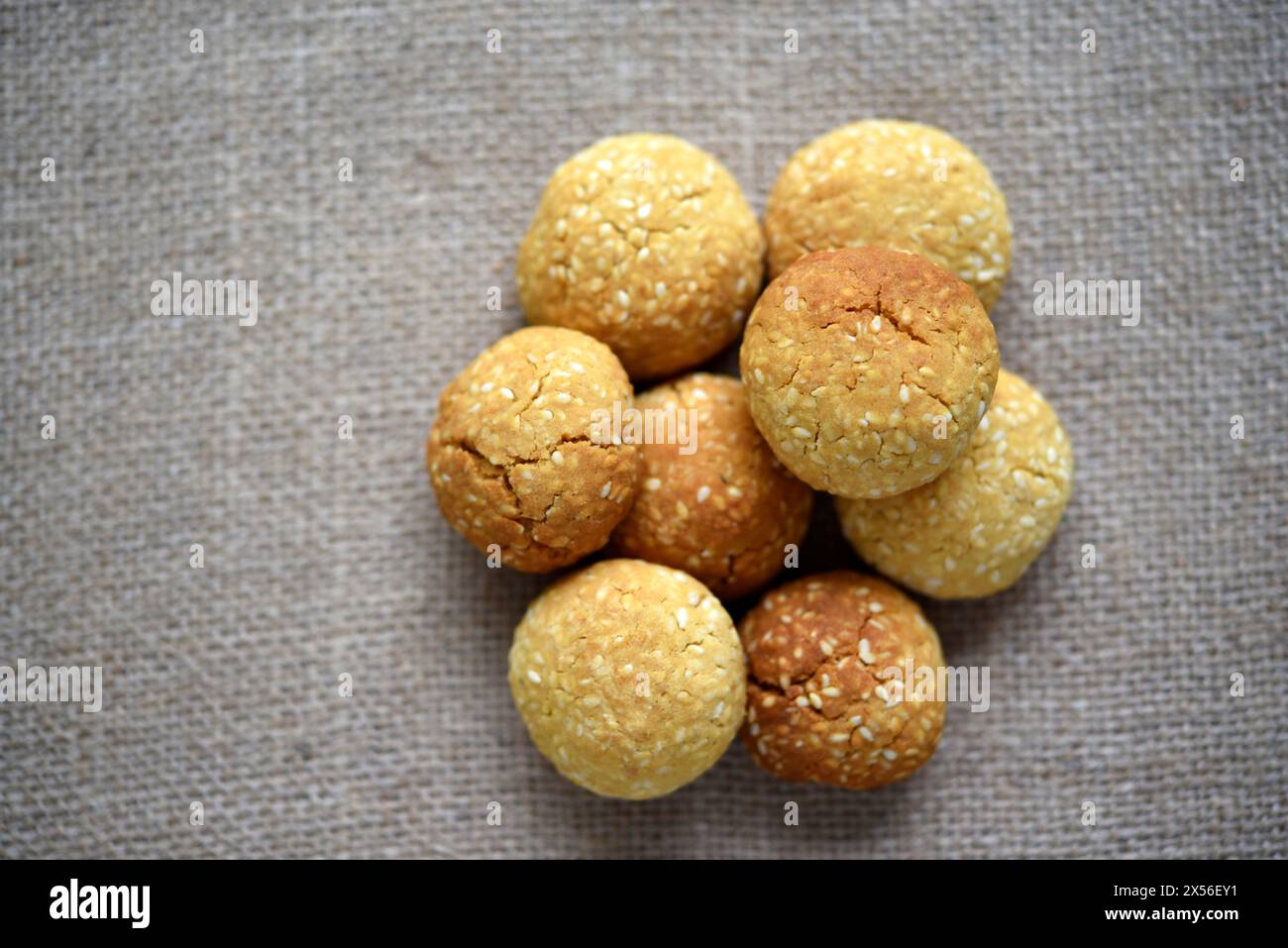 A pile of sesame cookies on a burlap bag. Sweet sugar yellow cookies. Stock Photo