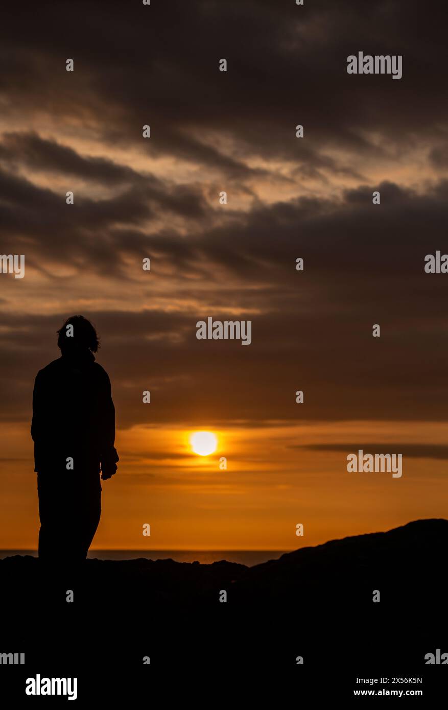 Woman alone watching sunset hi-res stock photography and images - Alamy