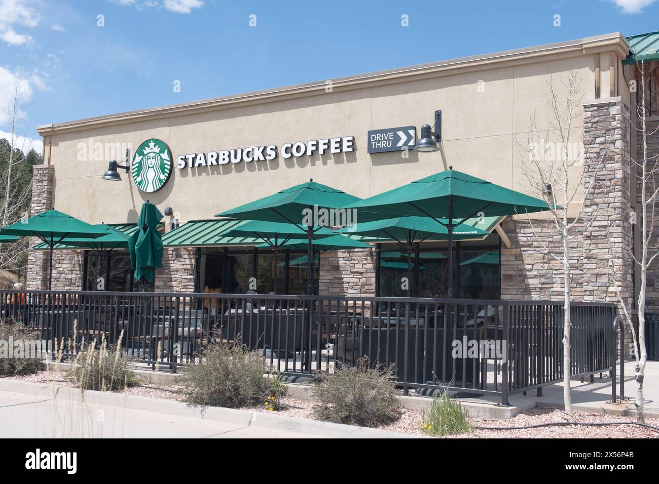Exteriors of modern Starbucks coffee locations with drive thru windows, located in shopping