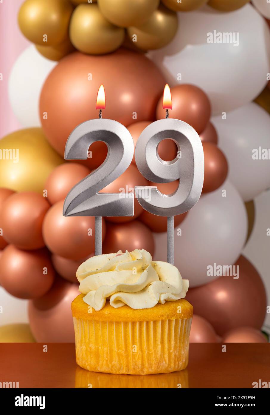 Cupcake with birthday candle on balloons background - Number 29 Stock Photo
