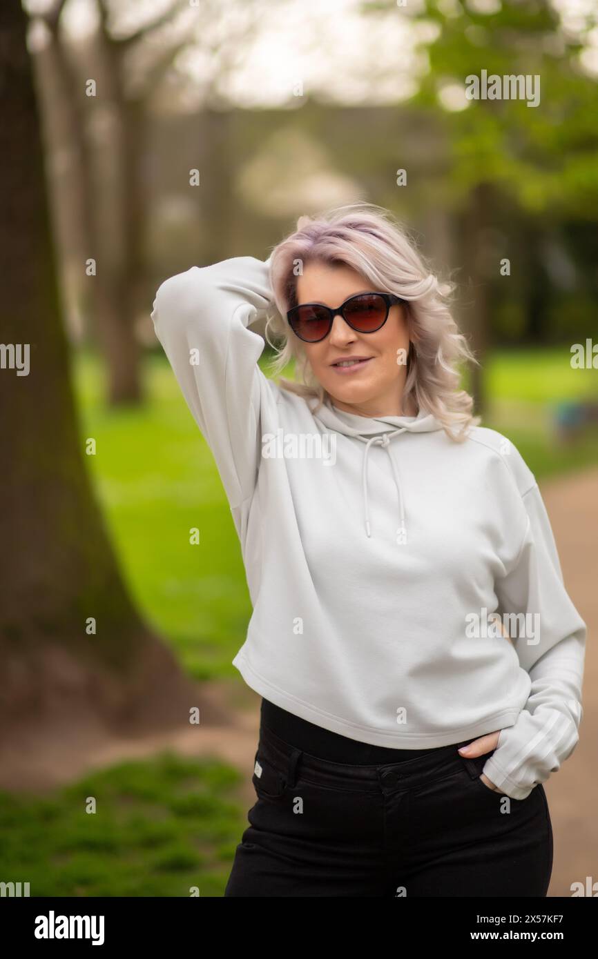 Stylish woman with silver hair in park. Stock Photo