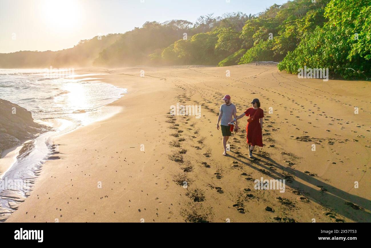 Two tourists walking on the sandy beach, Playa Cocalito, Puntarenas, Costa Rica Stock Photo