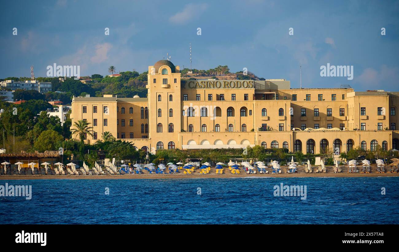 Casino building on the beach with parasols and clear sea, harbour area ...