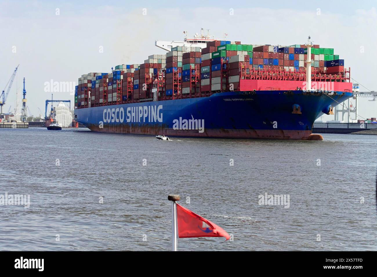Container freighter of the China Ocean Shipping Company COSCO leaving the harbour on a sunny day at the Elbe, Oat, Germany, Europe, Large blue Stock Photo