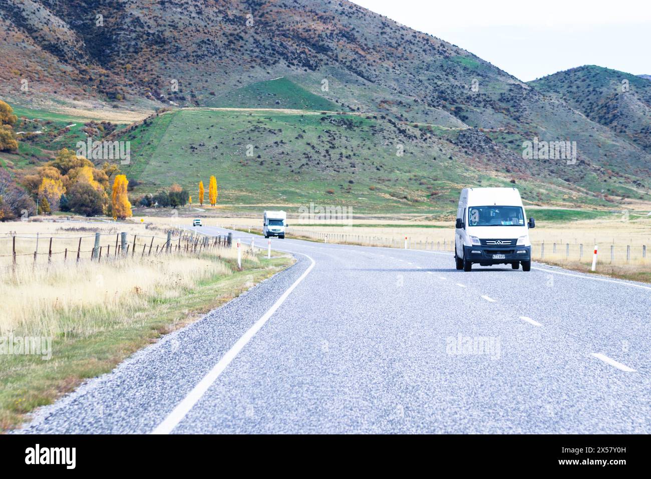 Central Otago, New Zealand - April 21, 2023: Vehicles travelling through the Lindis Pass Alpine Highway, New Zealand. Stock Photo