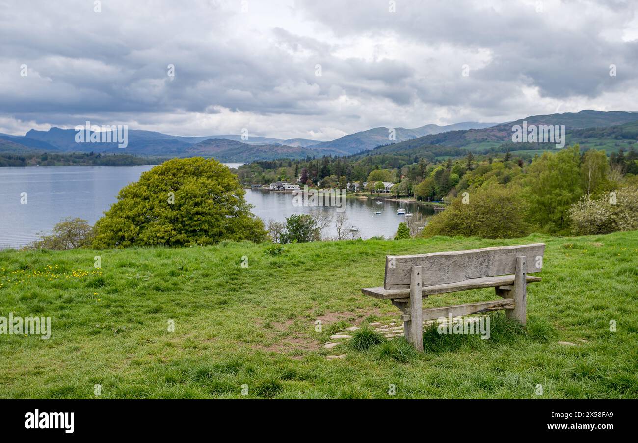 A bench with a stunning view from the vantage point of Queen Adelaides Hill which looks down on the East shore of Lake Windermere in the Lake District Stock Photo