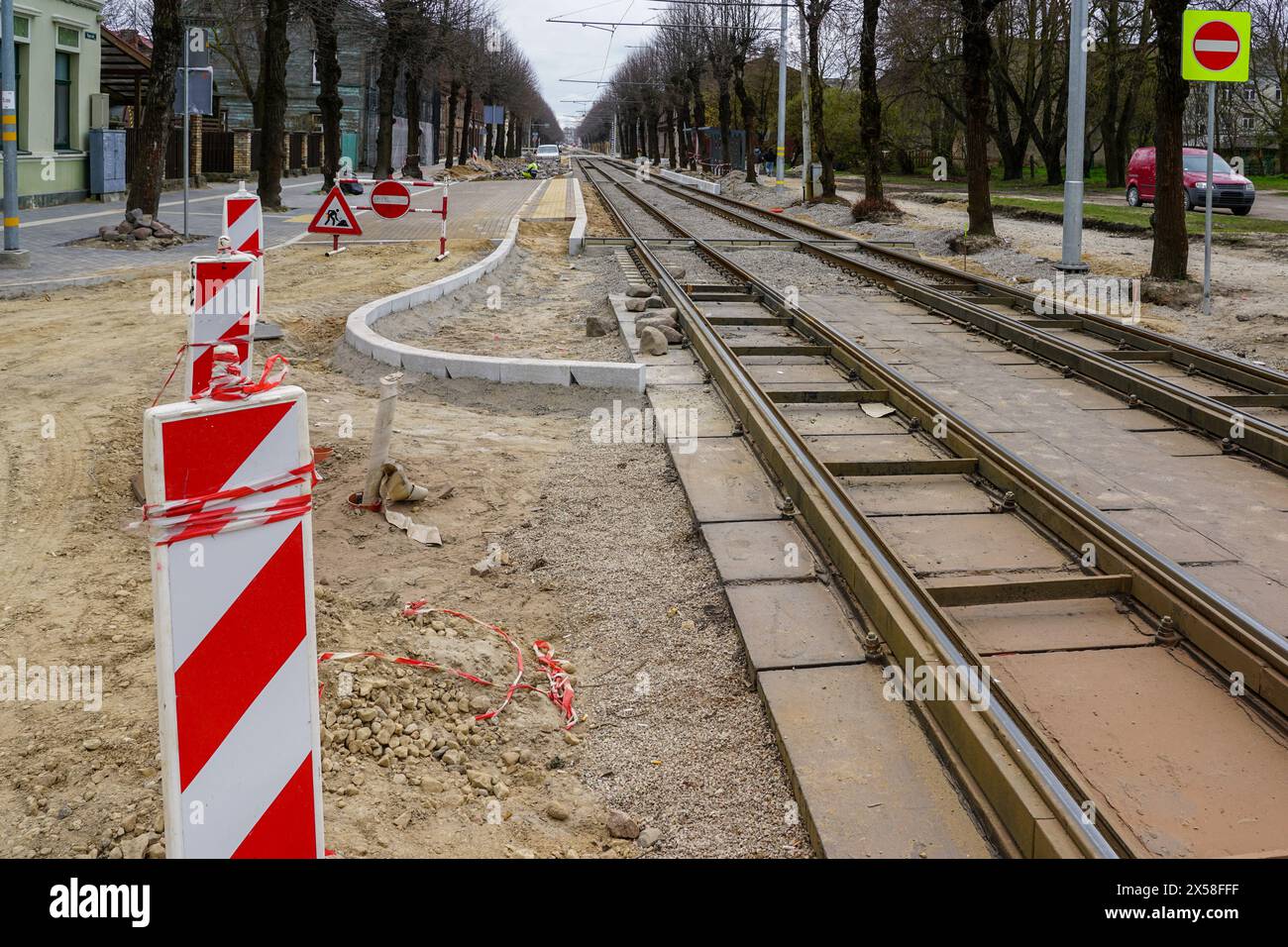 Unfinished construction of a new modern low-floor tram stop platform and replacement of tram rails on a city street Stock Photo