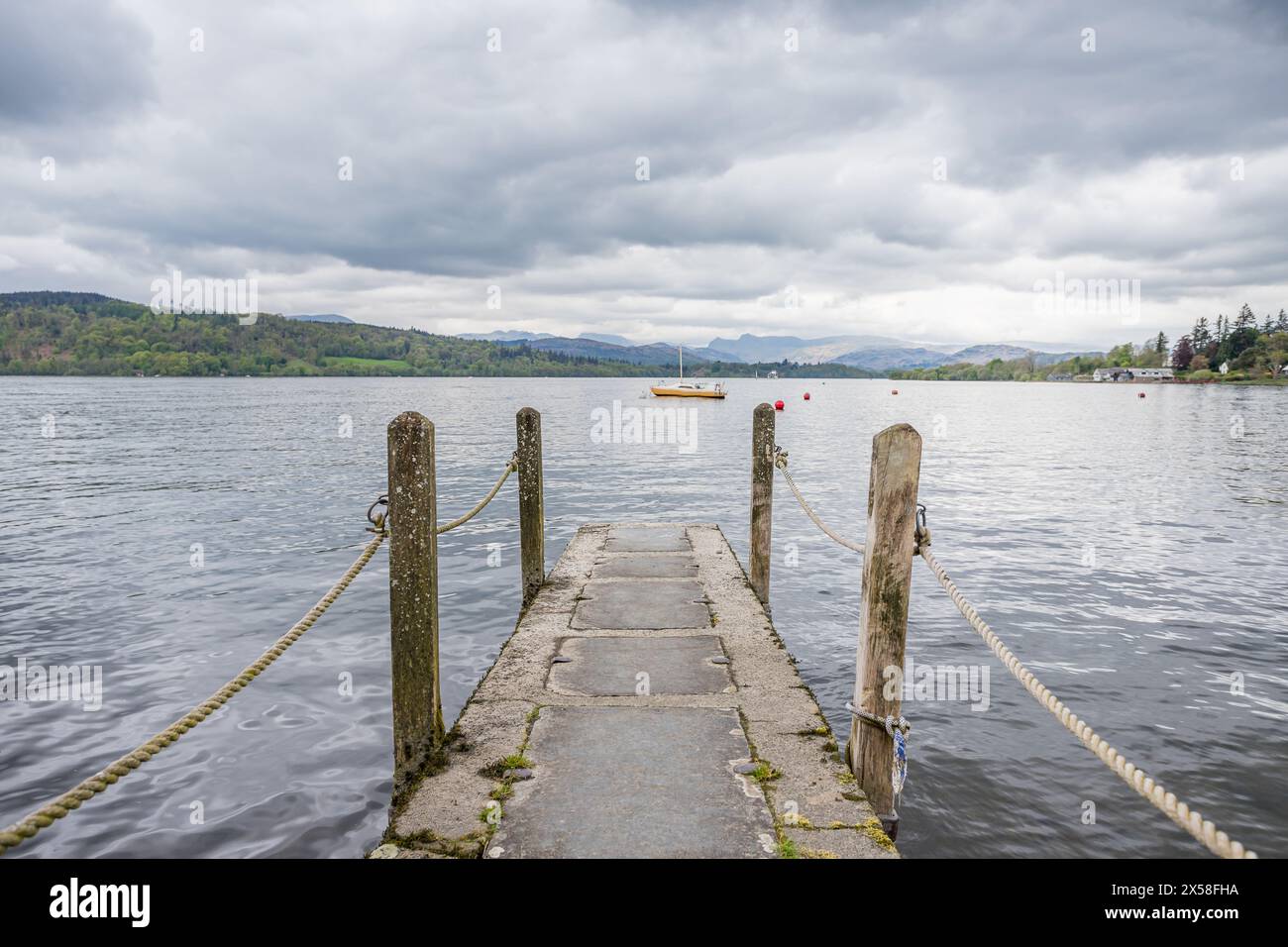 Looking along a concrete jetty with rope guards as it juts out into ...
