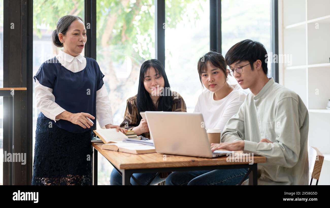 A positive and kind senior Asian female teacher is teaching her ...