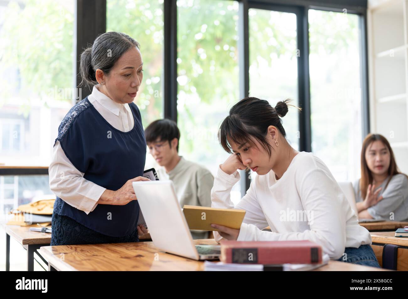Young student struggle to understand the lesson while teacher trying to ...