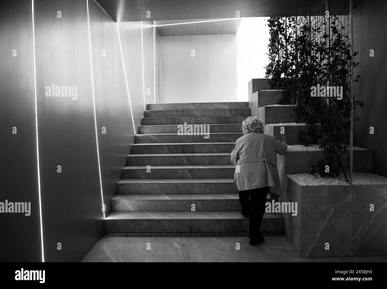 Elderly woman climbing pedestrian underpass stairs Stock Photo