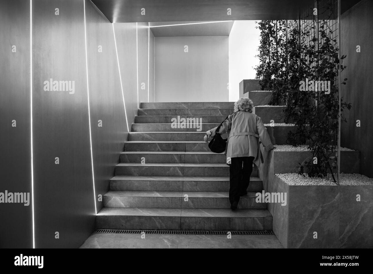 Elderly woman climbing pedestrian underpass stairs Stock Photo