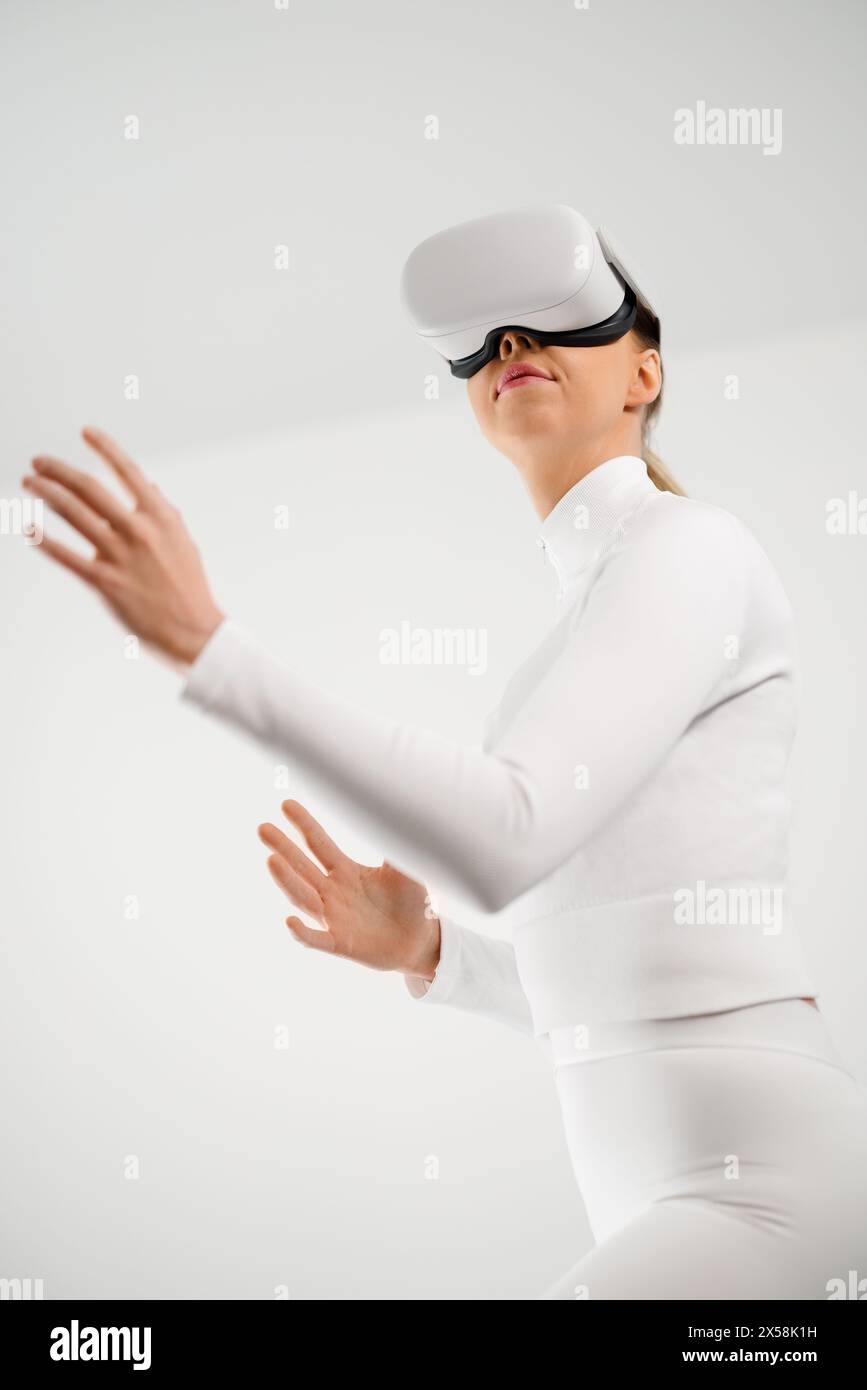 Young Woman Using Virtual Reality Headset in Minimal Setting Stock Photo