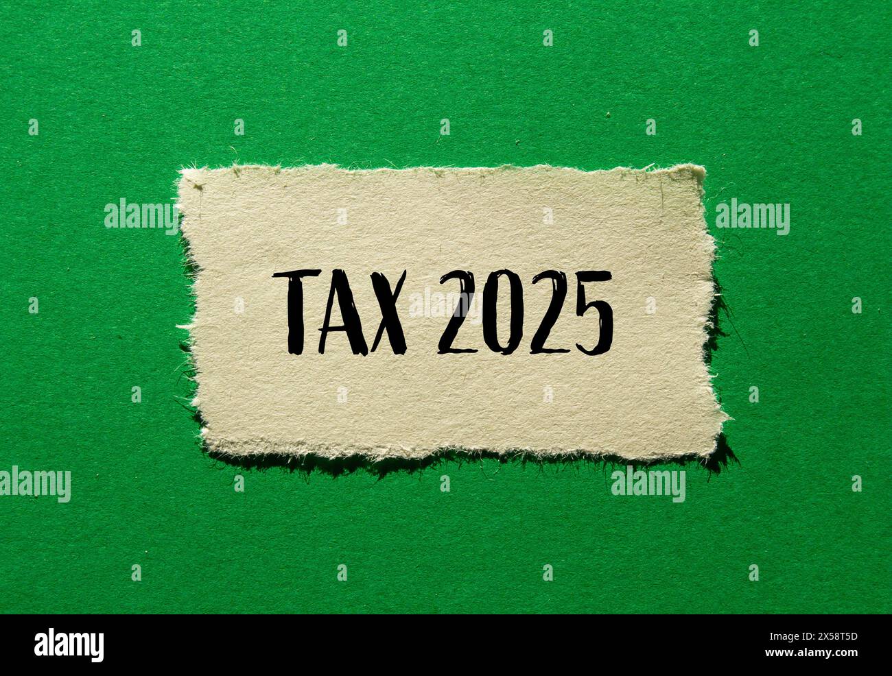 Tax 2025 words written on ripped paper with green background. Conceptual business tax 2025