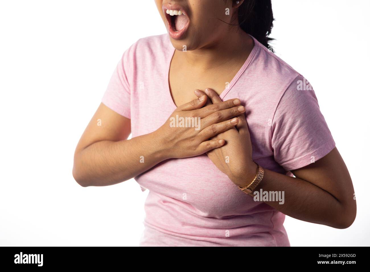 An Indian woman holding her chest for pain showing painful expression on white background Stock Photo