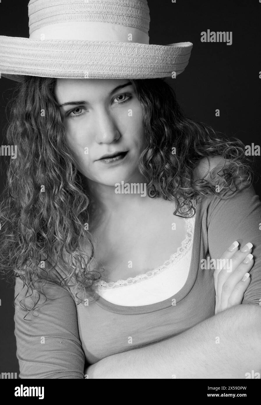 Stock photo of an angry young woman with arms crossed, wearing hat and looking into lens. USA Stock Photo