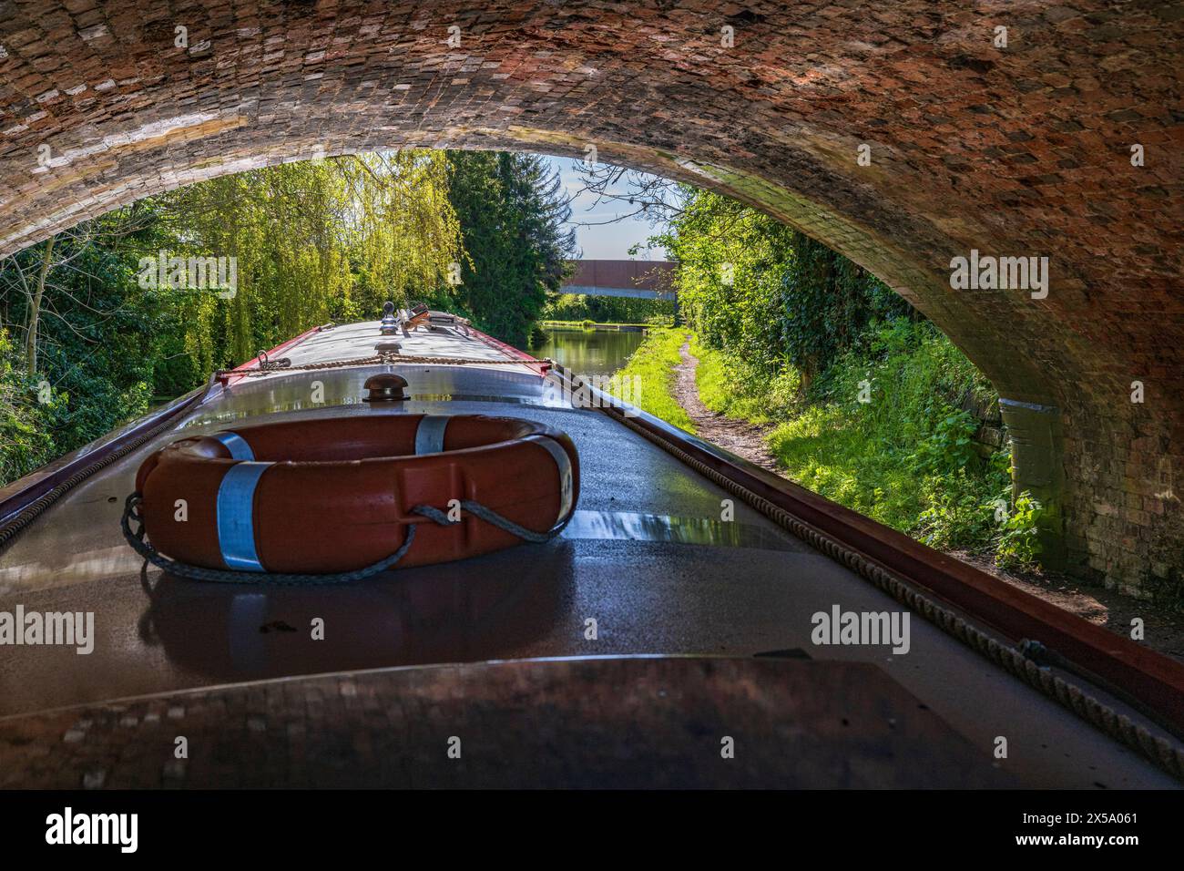 Rugby, Warwickshire, England - The Oxford Canal – A narrowboat under an old canal bridge Stock Photo