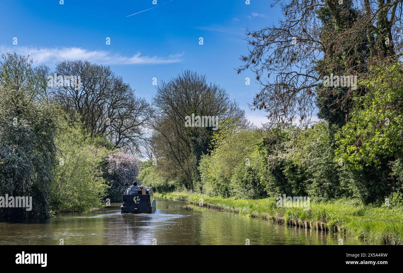 Oxford Canal, Near Rugby, England – A narrowboat on the canal on a bright summer day against a blue sky Stock Photo