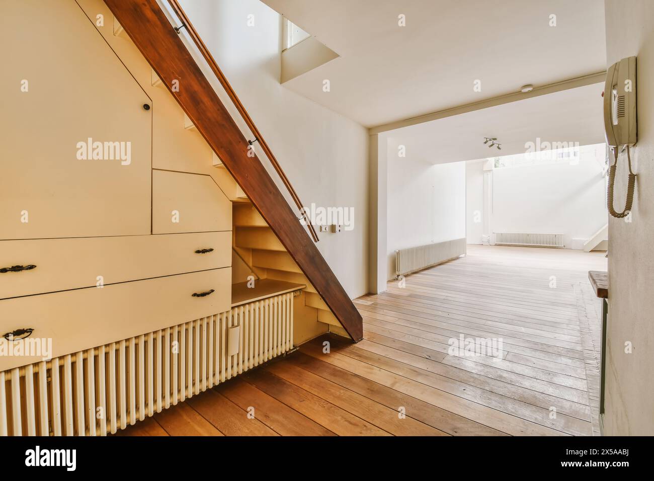An airy and well-lit attic room featuring a wooden staircase, built-in ...