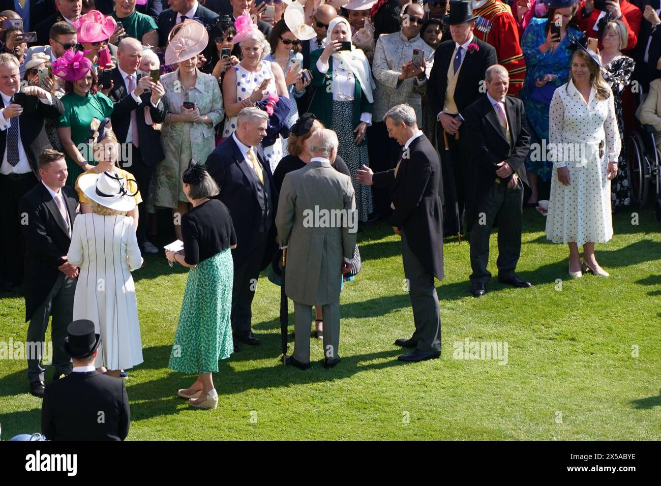 King Charles III and Queen Camilla speak to guests attending a Royal