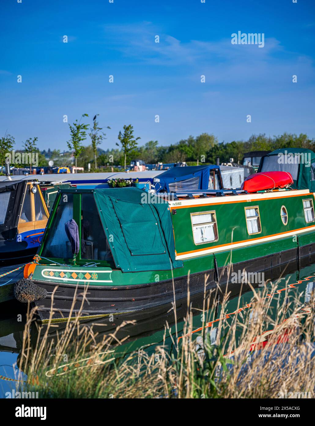 Dunchurch Pools Marina, Warwickshire, Oxford Canal – Summer morning  narrowboats in tranquil surroundings against a clear blue sky Stock Photo
