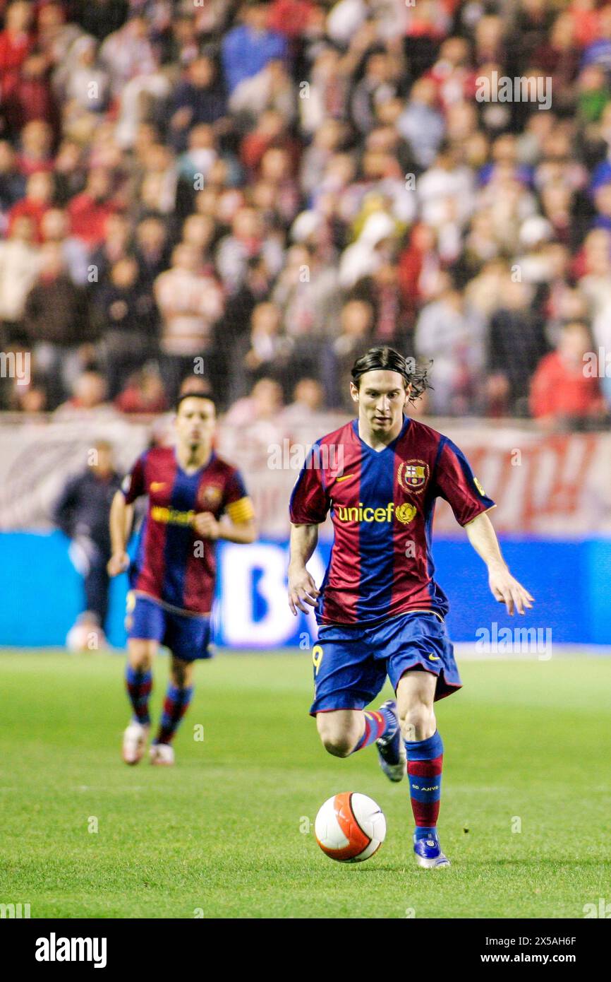Lionel Messi dribbles the ball in a pivotal match at Ramón Sánchez-Pizjuán Stadium, showcasing skill and focus Stock Photo
