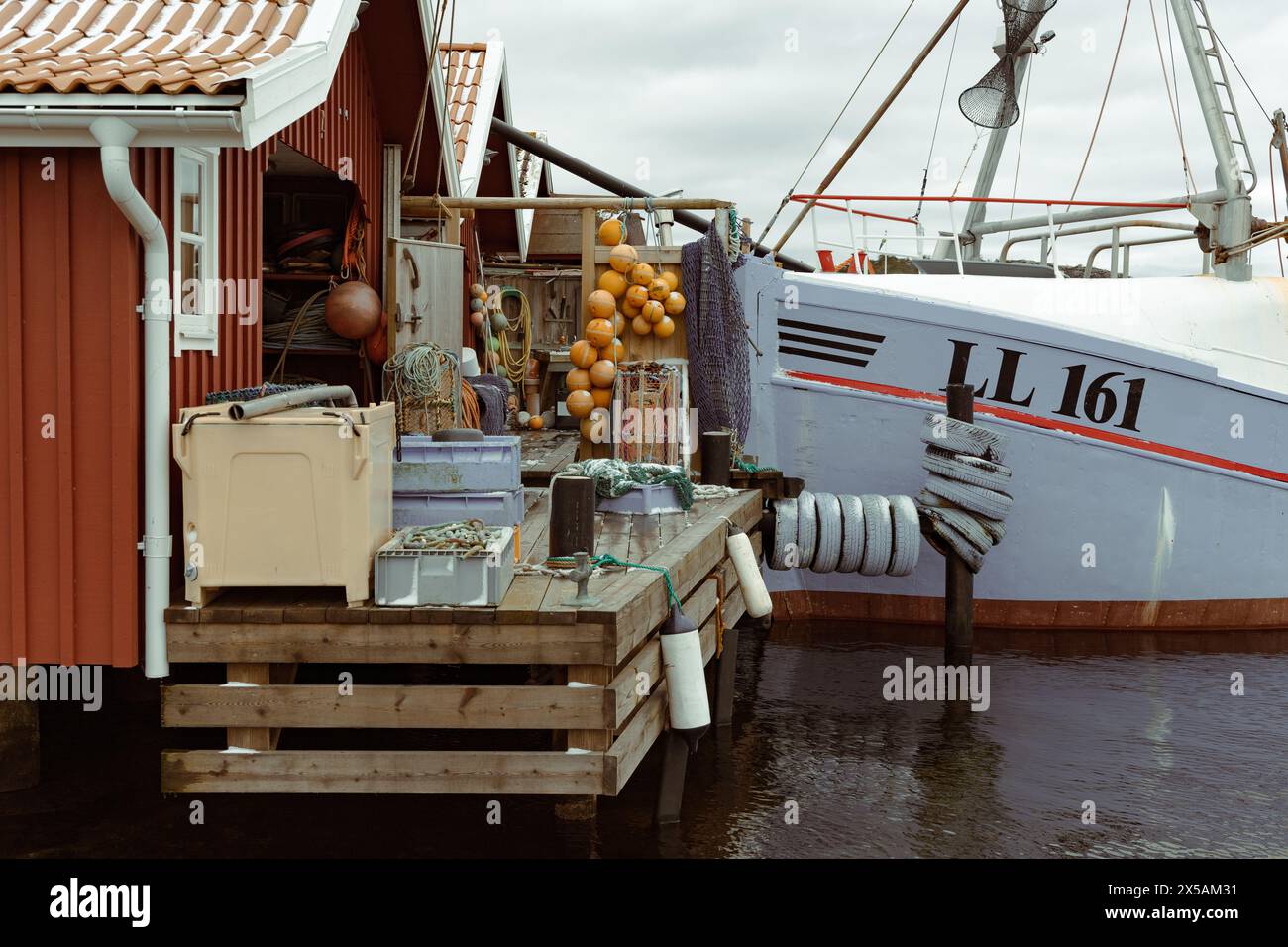 Ellös, Sweden - March 26 2023: Fishing utilities and bow of ship moored at fishing village hut. No visible people Stock Photo
