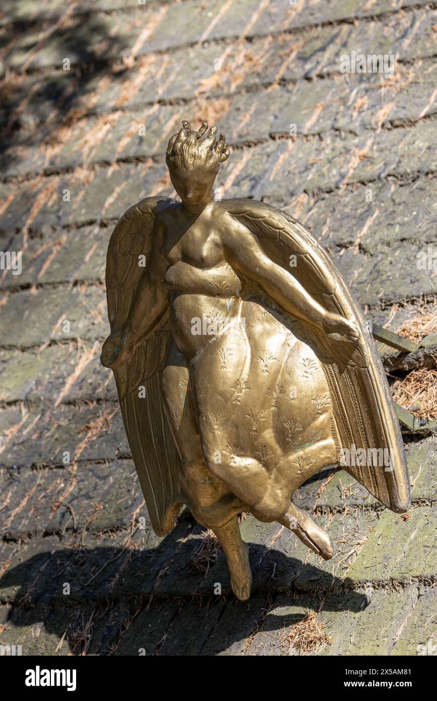 Stockholm, Sweden - April 15 2023: Golden angel statue in sunlight on roof of chapel at forest cemetary Stock Photo