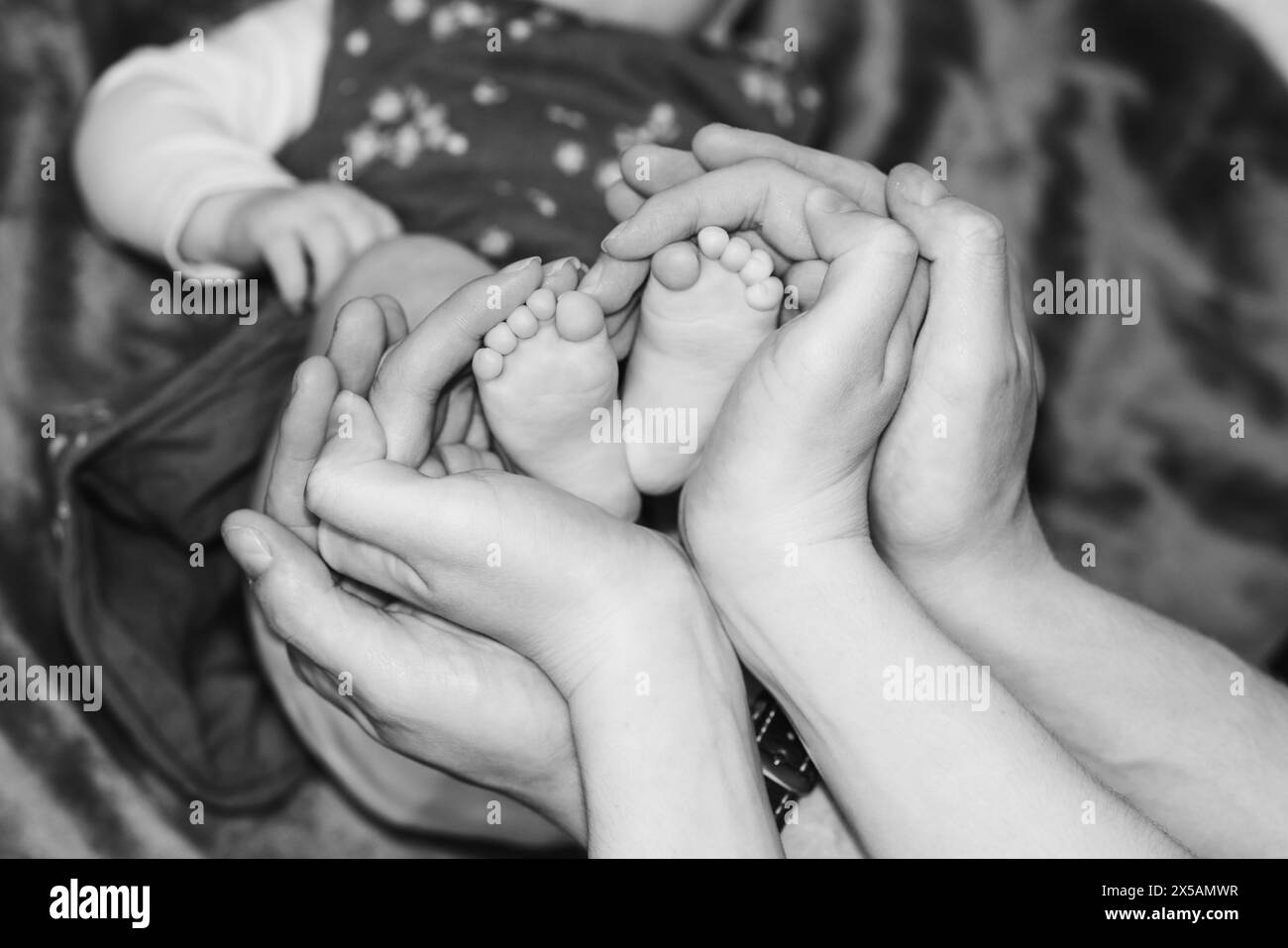 Hands of mom and dad around baby feet, heart shape, love, family, baby ...