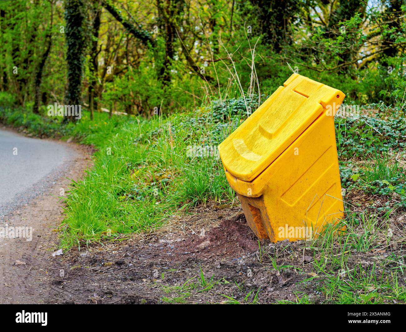 gritting bin by the road side yellow high visibility grit storage for slippy roads in winter. Stock Photo