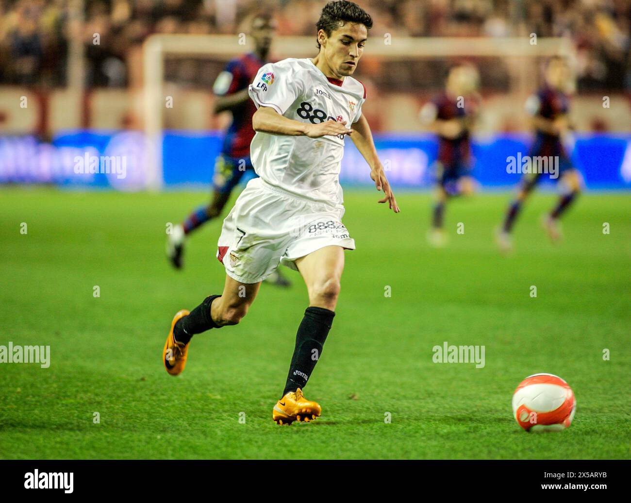 Soccer player Jesus Navas dribbling the ball at high speed during a match between Sevilla FC and FC Barcelona at Ramon Sanchez-Pizjuan stadium. Stock Photo