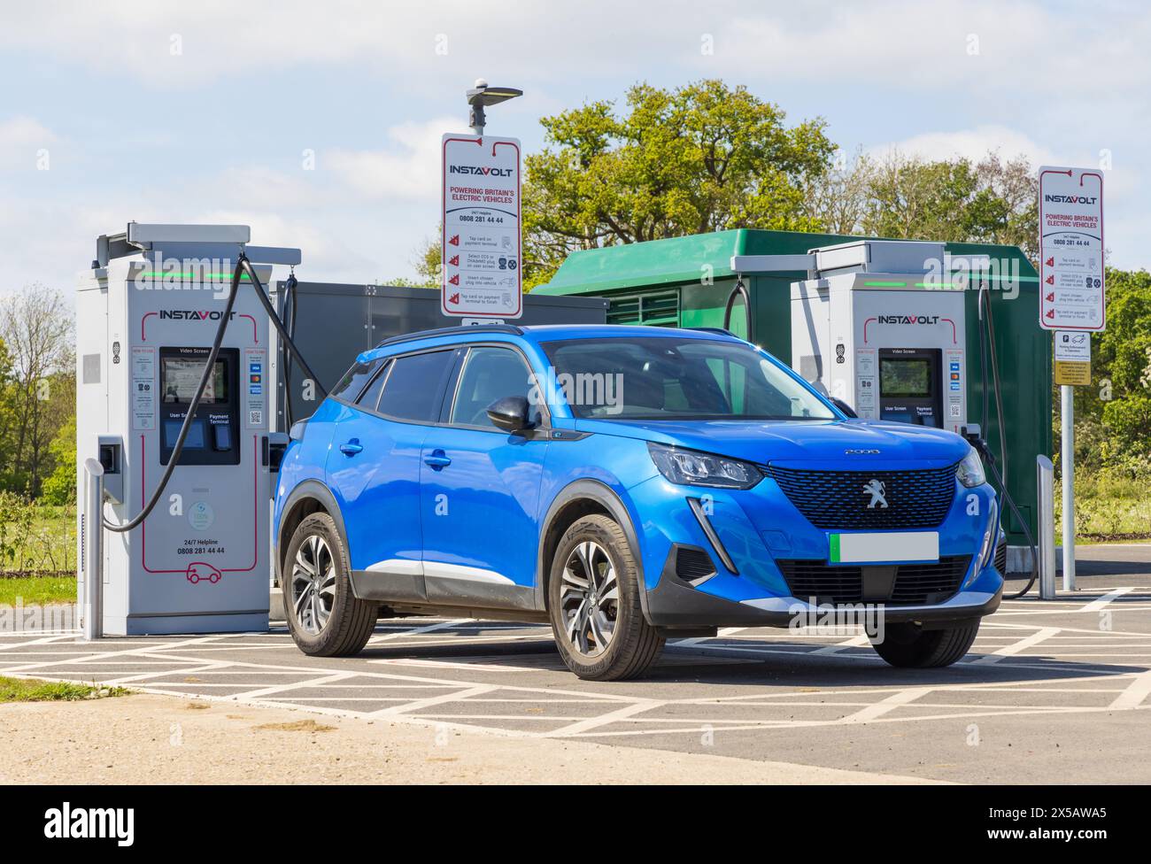 Peugeot electric car being charged at an InstaVolt EV charging station., Suffolk. UK Stock Photo